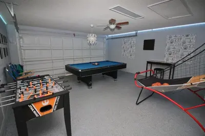 a room with a ping pong table and a pool table at Gorgeous 4 Bed Home In Gated Community in Kissimmee