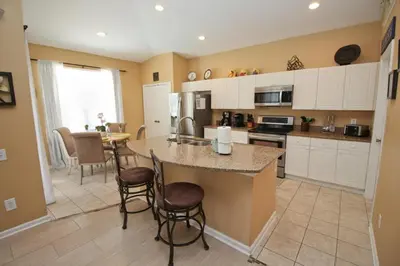 a kitchen with a large island with bar stools at Luxury Villa Private Pool And Great Game Room in Kissimmee