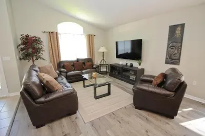 a living room with leather furniture and a flat screen tv at Newly Renovated Home With Calming Atmosphere in Kissimmee