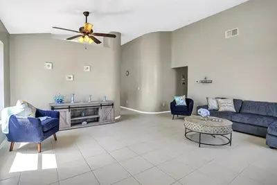 a living room with a blue couch and chairs at 4716 Windwood Magic Villa pool in Kissimmee