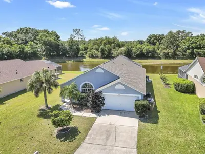 an aerial view of a house with a lake at 4716 Windwood Magic Villa pool in Kissimmee