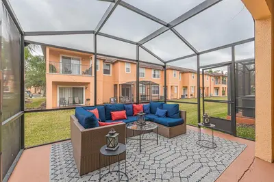 a screened in patio with a couch and tables at 2711 - Jungle Book Bungalow - DO NOT DO in Orlando
