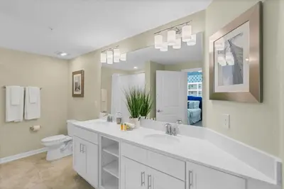 a bathroom with a sink and a toilet and a mirror at 3120 Paradox Circle 301 in Kissimmee