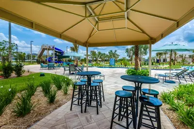 a patio with tables and stools and a playground at 3120 Paradox Circle 301 in Kissimmee