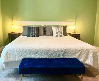 a bedroom with a large bed with a blue bench on it at Sweet Stay with fully fenced yard in Sanford