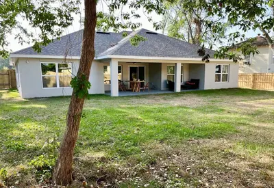 a white house with a tree in the yard at Sanford's Seahaven in Sanford