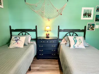 a bedroom with two beds and a night stand with a lamp at Sanford's Seahaven in Sanford