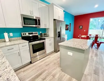 a kitchen with white cabinets and a counter top at The Arcade close to downtown with fenced yard in Sanford