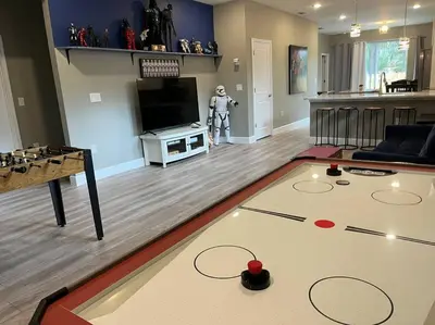 a living room with a table and a video game at The Billiard close to downtown with fenced yard in Sanford