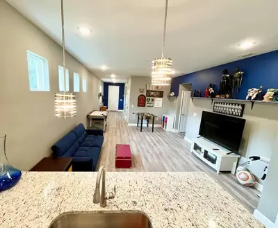 a living room with a blue couch and a tv at The Billiard close to downtown with fenced yard in Sanford