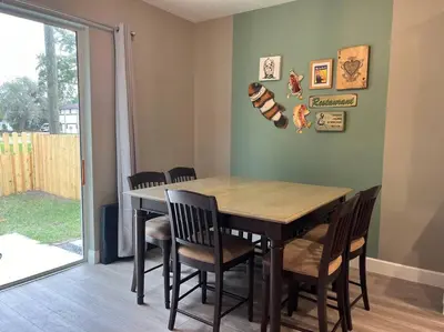 a dining room with a wooden table and chairs at The Billiard close to downtown with fenced yard in Sanford