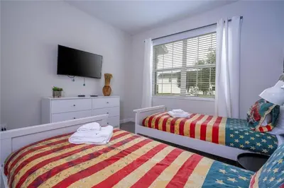a bedroom with two beds and a flat screen tv at Amazing home at Storey lake 2 minutes to clubhouse in Kissimmee