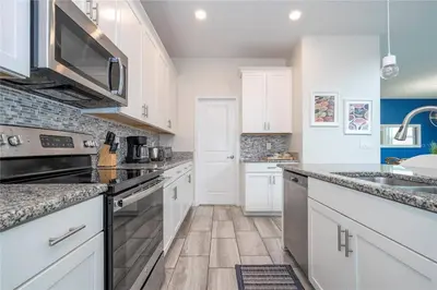 a kitchen with white cabinets and a counter top at Amazing home at Storey lake 2 minutes to clubhouse in Kissimmee