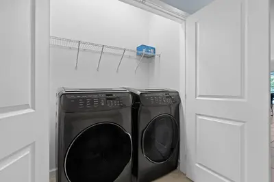 two black washing machines in a white laundry room at Cozy Master Room with Private Bath in Kissimmee