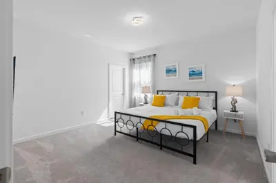 a white bedroom with a bed with yellow pillows at Cozy Master Room with Private Bath in Kissimmee