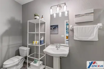 a bathroom with a sink and a toilet and a mirror at The Epic Colorado Vista Cay Orlando in Orlando