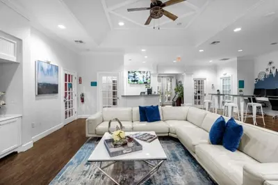 a living room with a white couch and blue pillows at Your VIP Home in Orlando Disney 25106 in Kissimmee