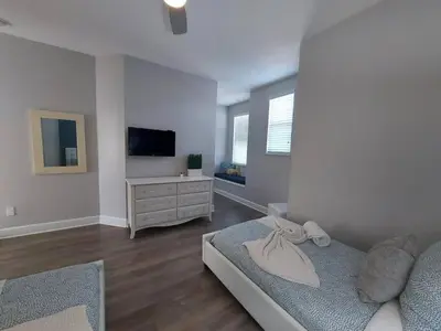 a bedroom with a bed and a dresser and a tv at Serenity Close to Disney Orlando in Orlando