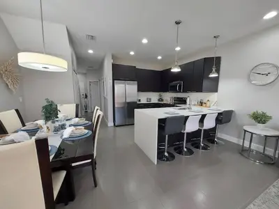 a kitchen and dining room with a table and chairs at Serenity Close to Disney Orlando in Orlando