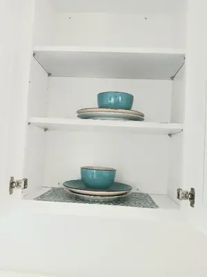 two bowls and plates on shelves in a cabinet at Nard Jolie Kay in Kissimmee