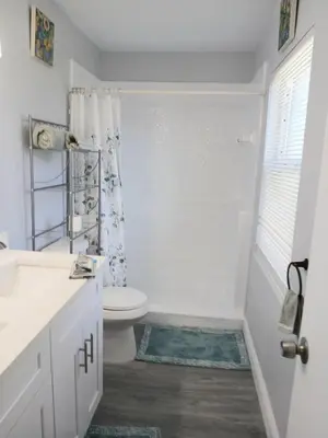 a white bathroom with a toilet and a shower at Nard Jolie Kay in Kissimmee