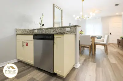 a kitchen with a dishwasher and a dining room at NEW Renewed 3BD Modern 10 Min to Disney in Kissimmee