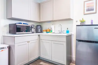 a kitchen with white cabinets and a stainless steel refrigerator at NEW Designed Apt 2023 NrUCF PETSOk PrivateEntry in Orlando