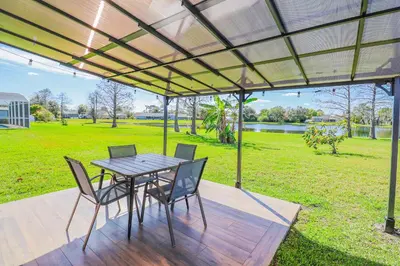 a patio with a table and chairs and a field at BRANDNEW 2023 LAKEFRONT APT in Kissimmee
