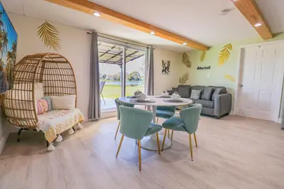 a living room with a table and chairs and a couch at BRANDNEW 2023 LAKEFRONT APT in Kissimmee