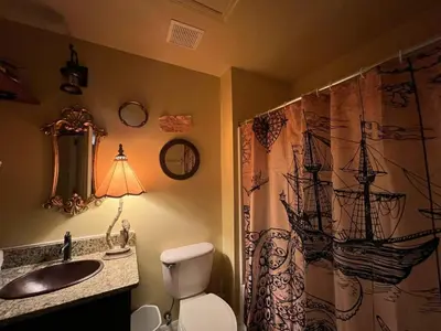 a bathroom with a toilet and a sink and a shower curtain at Magical Themed Home, Potter, Peter Pan 3mi Disney in Kissimmee