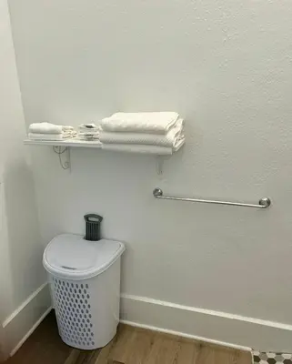a bathroom with a toilet and towels on a wall at Renovated Peaceful Luxury Walk to Mall Park Publix in Orlando