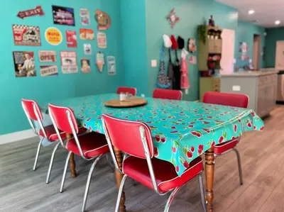 a dining room table with red chairs and a green table cloth at The Sanford Bandstand in Sanford