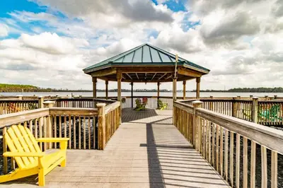 a wooden boardwalk with a gazebo and a yellow bench at Orlando 4th Floor - 5 min Disney in Orlando