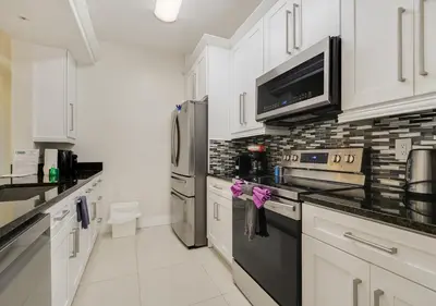 a kitchen with white cabinets and stainless steel appliances at Wonderful Life at Windsor Hills in Orlando