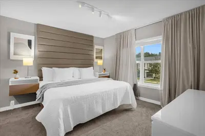 a bedroom with a large white bed and a window at Themed Home Near Disney with Pool in Kissimmee