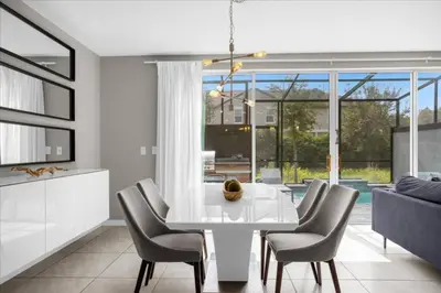 a dining room with a white table and chairs at Themed Home Near Disney with Pool in Kissimmee