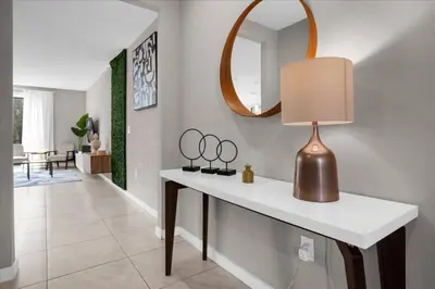 a room with a table with mirrors and a lamp at Themed Home Near Disney with Pool in Kissimmee