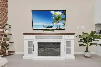 a living room with a fireplace with a tv on top at Enchanted Home Near Disney in Orlando