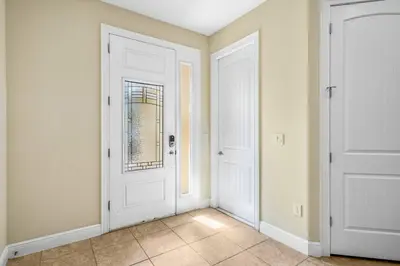 a hallway with two white doors and a tile floor at Encore Resort 5 Bedroom Home with Pool 2403 in Orlando