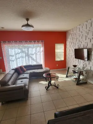 a living room with a couch and a flat screen tv at Island Abode -near Disney in Kissimmee