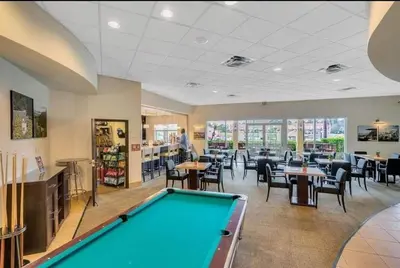a pool table in a room with tables and chairs at Island Abode -near Disney in Kissimmee