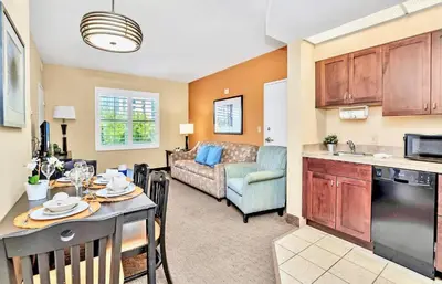 a kitchen and living room with a table and a couch at Contemporary Apartment with Pool Hot Tub - Close to Universal Studios in Orlando