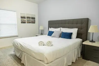 a bedroom with a large white bed with two towels at Charming decorated 3BED at West Lucaya Resort 55 in Kissimmee