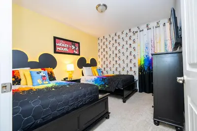 a bedroom with two beds and a tv in it at 510 BS - 5BD Cozy Family Haven with Pool in Orlando