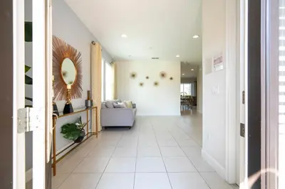 a hallway with a couch and a mirror at 510 BS - 5BD Cozy Family Haven with Pool in Orlando
