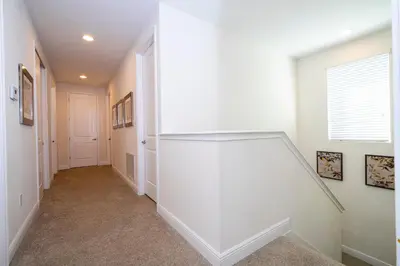 a hallway of a home with white walls and a staircase at 510 BS - 5BD Cozy Family Haven with Pool in Orlando