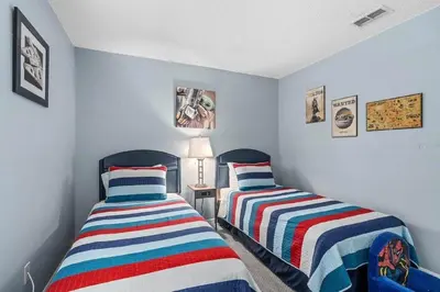 two beds in a room with blue walls at Private Pool Close to Disney Lg Hm Slps 8 in Kissimmee
