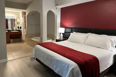 a bedroom with a bed and a bathroom with a tub at Spider-Man-themed condo near Disney, Sea World, Universal and OCCC with pool, spa, restaurants, shuttle, private balcony, and view of fireworks shows in Orlando