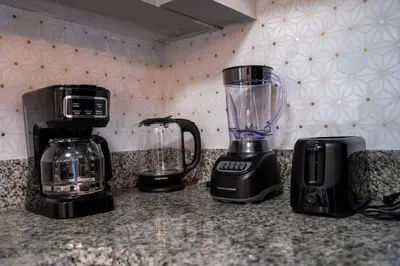 a kitchen counter with a blender and a coffee maker at 2 suites ground floor apartment near Intern Drive in Orlando