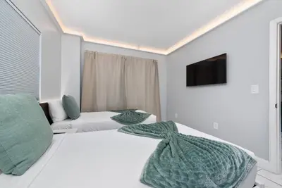 a hotel room with two beds and a tv at 2 suites ground floor apartment near Intern Drive in Orlando